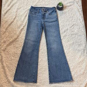 Express '70s Flare Low Rise Jeans in a medium wash with a raw hem.  Size 4R